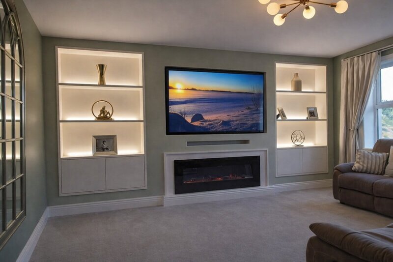 Custom media wall installation with LED shelving and electric fireplace by Lawday Construction, Devon