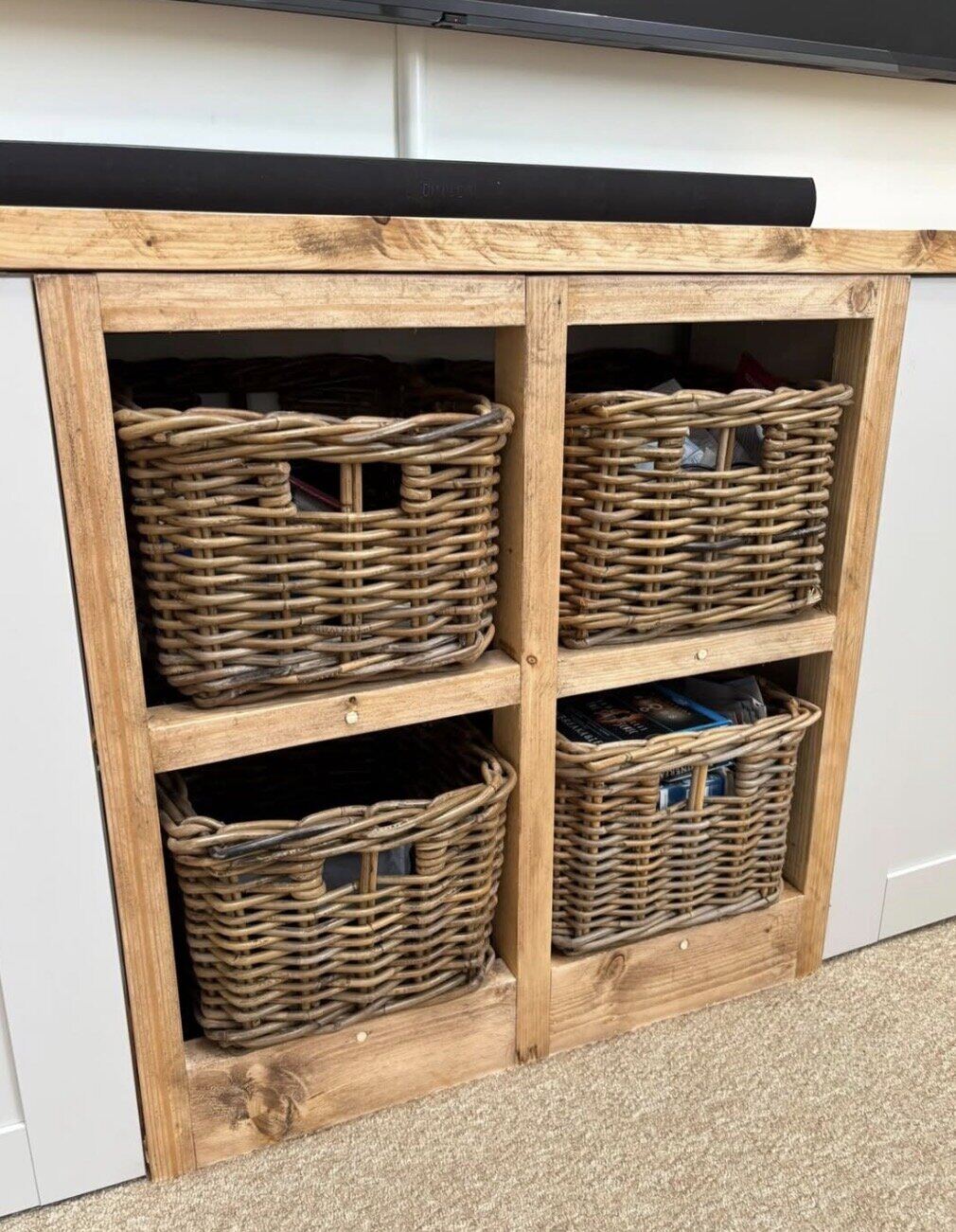 Storage cubby with woven baskets beneath media wall