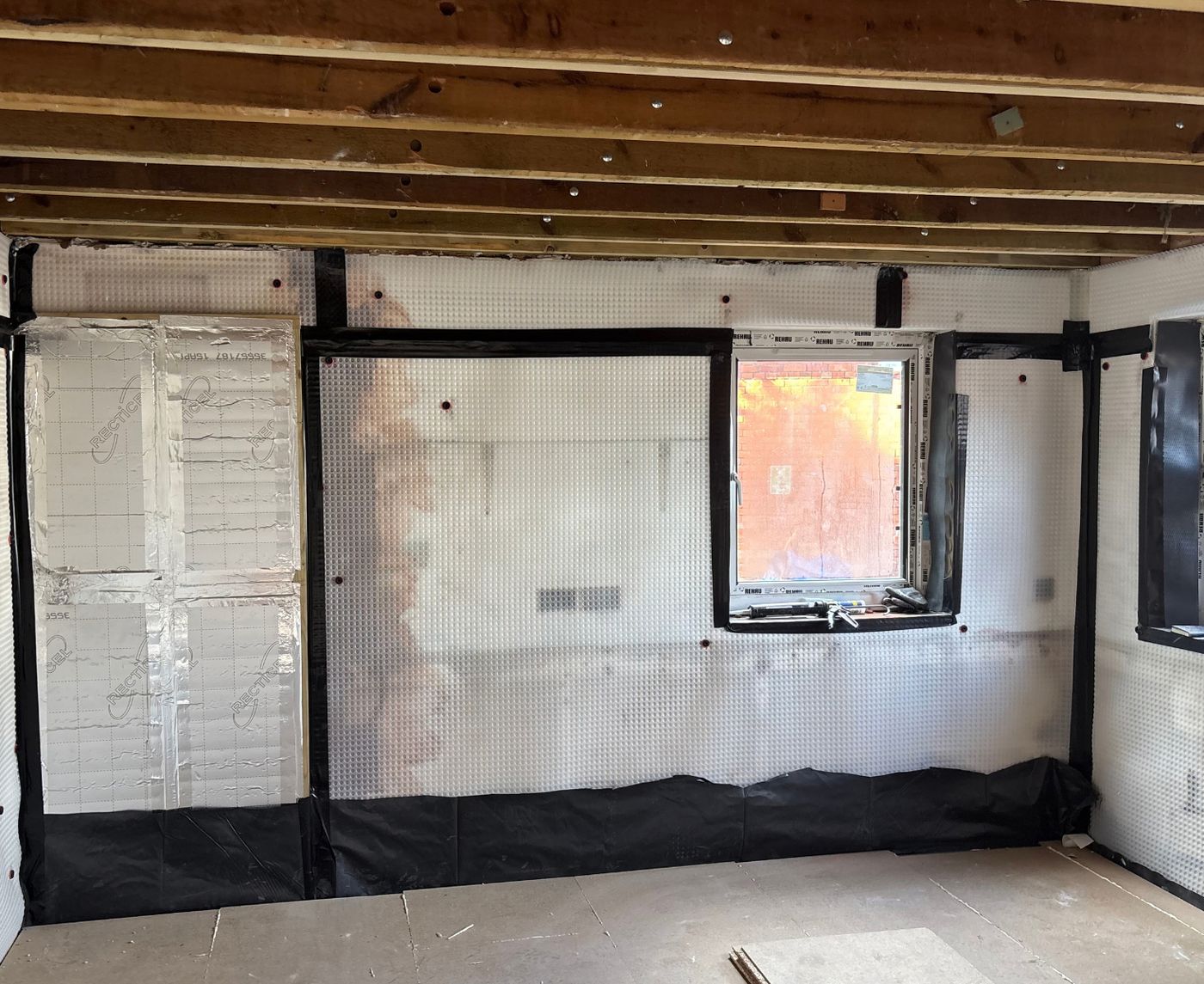 Room lined with damp proof membrane, ready for studwork and insulation
