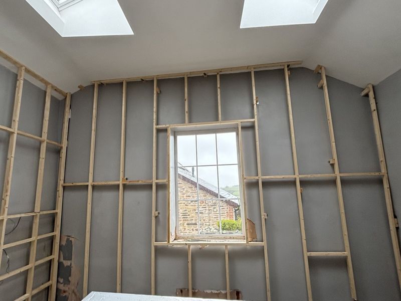 Studwork across multiple walls including window