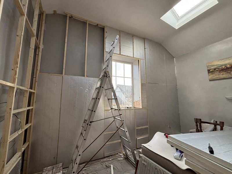 Insulation being installed between studwork